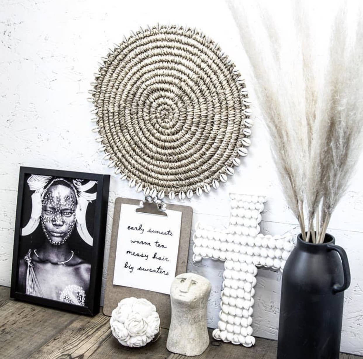 Croix Kai en coquillages blancs dans un décor à l'ambiance zen avec une décoration naturelle.