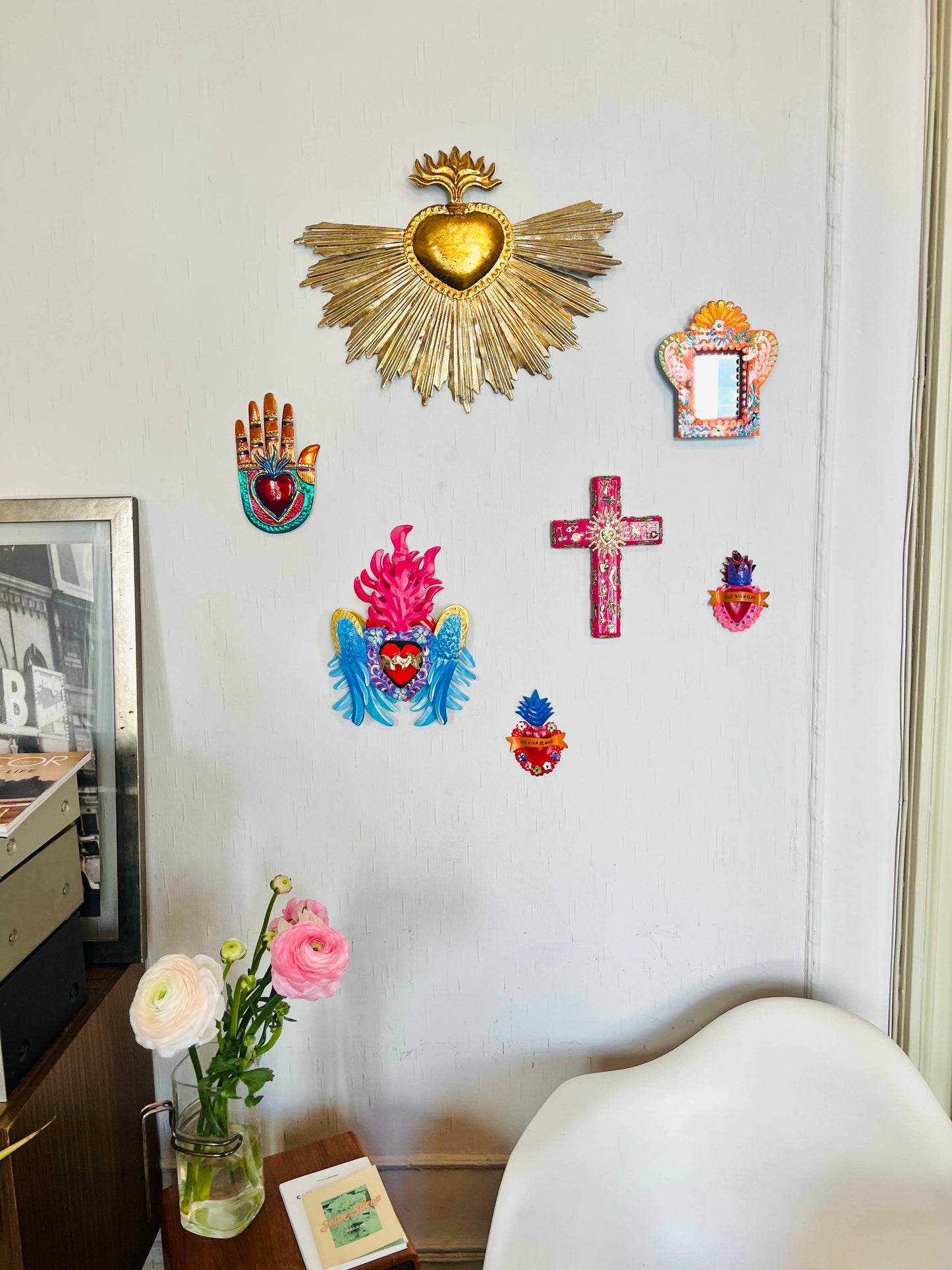 Vue de la croix en décoration murale au milieu d'autres ex-votos et ornements ethniques et bohèmes.