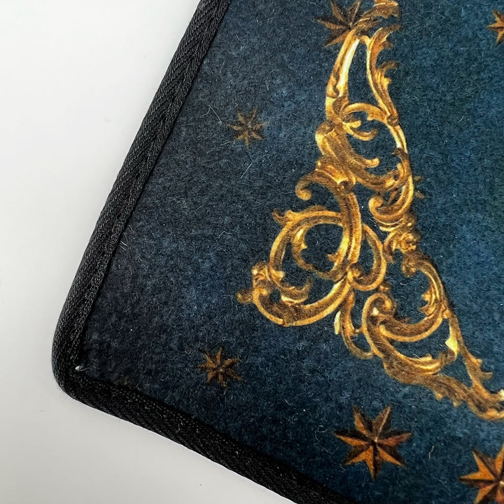 Détail du tapis de tirage en feutrine avec biais noir sur le pourtour pour une finition de haute qualité.